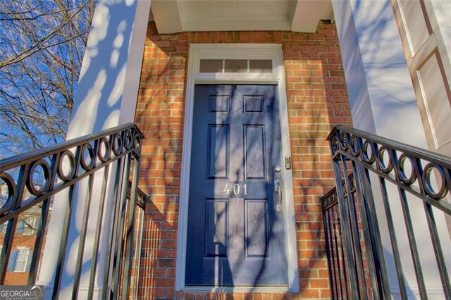 doorway to property featuring brick siding