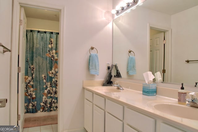 full bathroom featuring tile patterned flooring, double vanity, curtained shower, and a sink