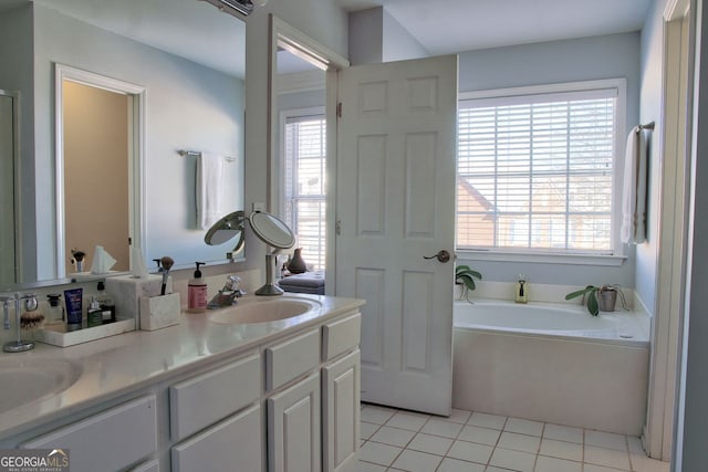 bathroom featuring double vanity, plenty of natural light, a bath, and a sink