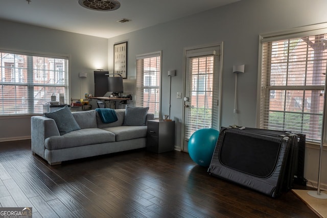 living room with visible vents, dark wood-type flooring, and baseboards