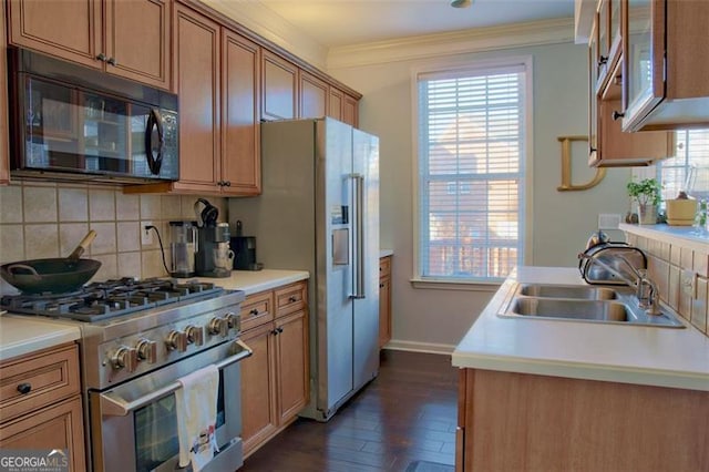 kitchen with a sink, black microwave, high end stainless steel range oven, crown molding, and tasteful backsplash