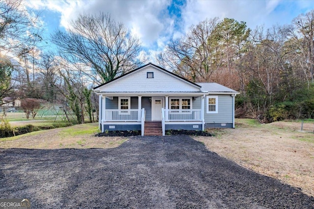 bungalow-style house featuring crawl space, covered porch, and metal roof