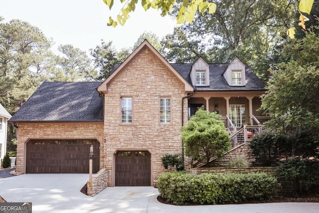 view of front of home with stairs, concrete driveway, stone siding, and roof with shingles