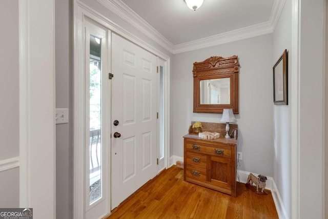 entryway featuring light wood finished floors, crown molding, and baseboards