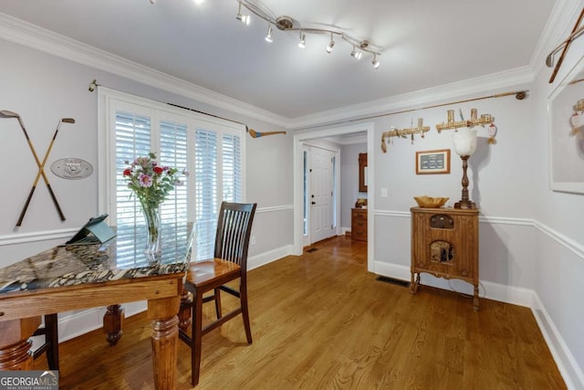 dining space featuring light wood-style flooring, baseboards, and ornamental molding