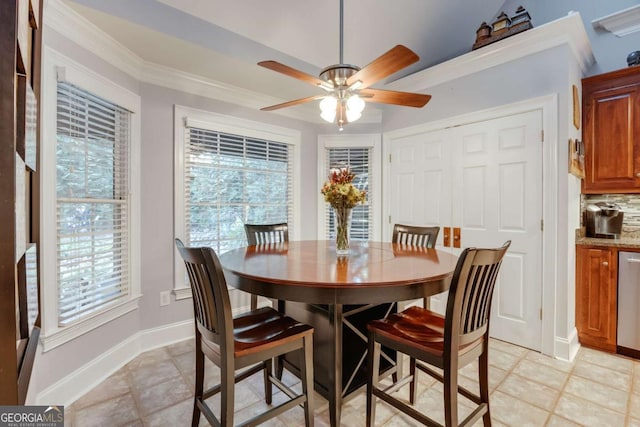 dining area with baseboards, crown molding, and ceiling fan