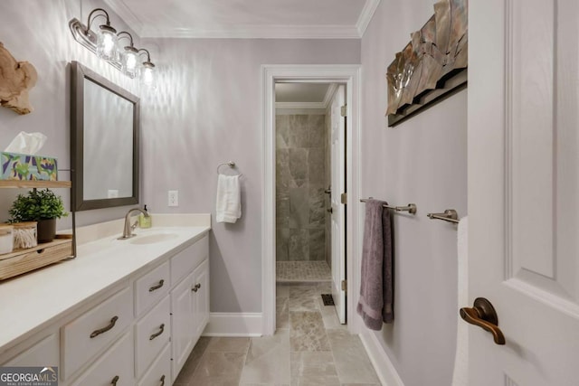 bathroom with vanity, tiled shower, baseboards, and ornamental molding