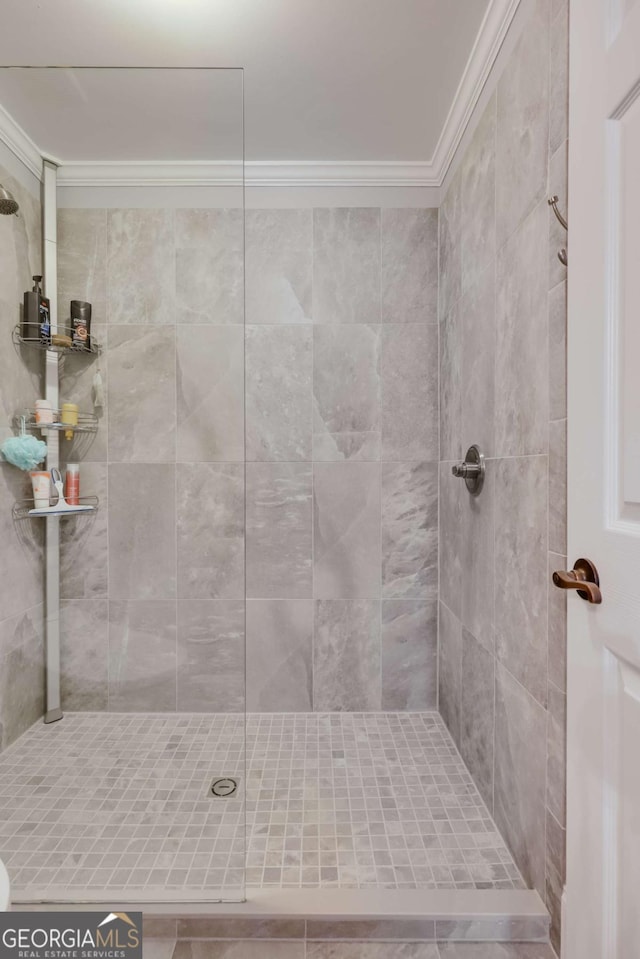 full bath featuring tiled shower and crown molding