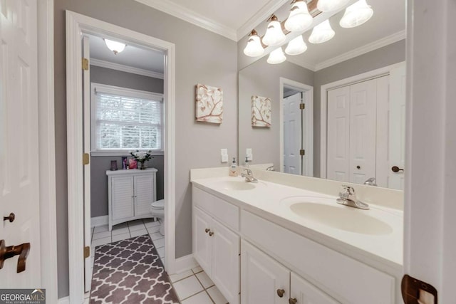 bathroom with double vanity, toilet, crown molding, and a sink