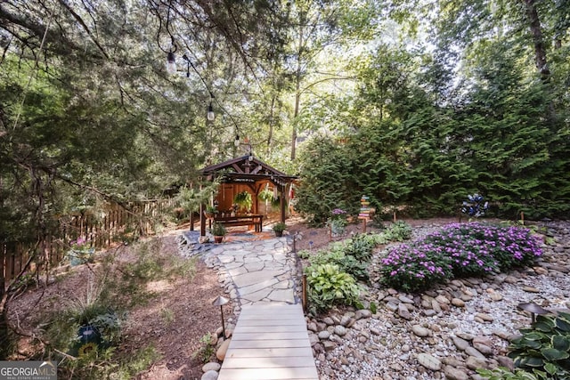 view of yard featuring a gazebo and a forest view