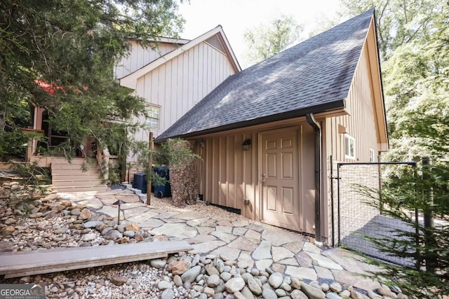 view of side of home featuring board and batten siding and roof with shingles