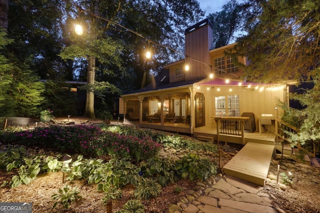 rear view of house featuring a deck and a sunroom