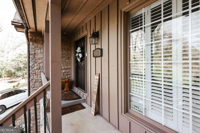 doorway to property with stone siding and covered porch