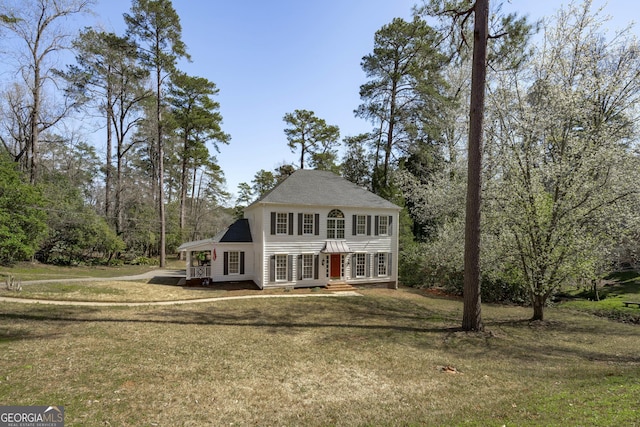 colonial-style house featuring a front yard