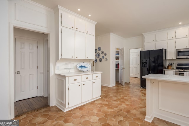 kitchen with white cabinetry, appliances with stainless steel finishes, crown molding, and light countertops