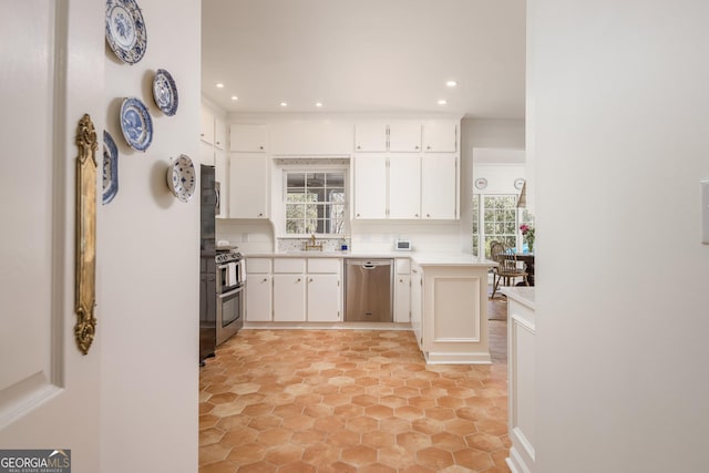 kitchen featuring light countertops, recessed lighting, white cabinets, stainless steel appliances, and a sink