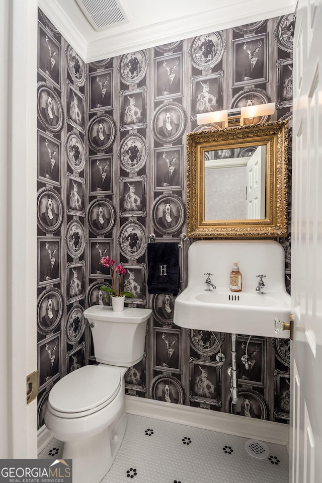 half bath featuring tile patterned floors, visible vents, toilet, and vanity