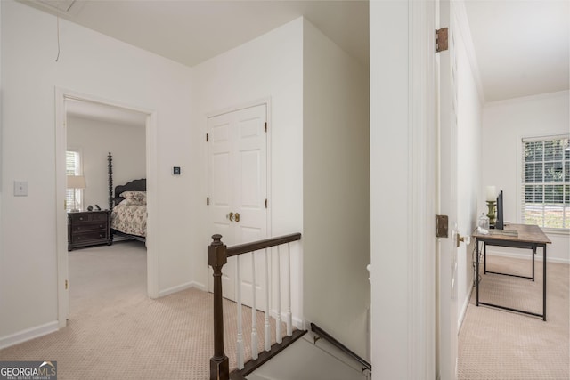hall with baseboards, carpet floors, attic access, and an upstairs landing