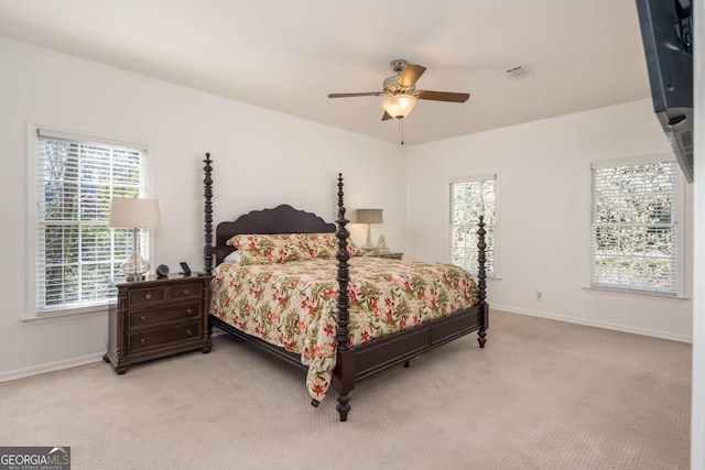 bedroom featuring ceiling fan, visible vents, baseboards, and light carpet
