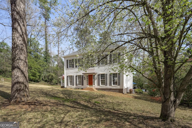 colonial-style house featuring a front lawn and crawl space