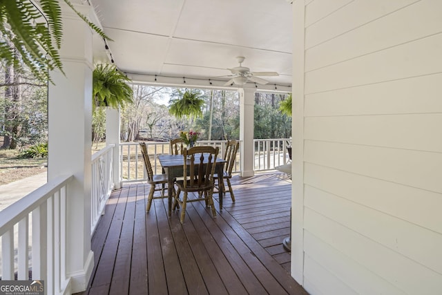 wooden deck featuring outdoor dining area and ceiling fan