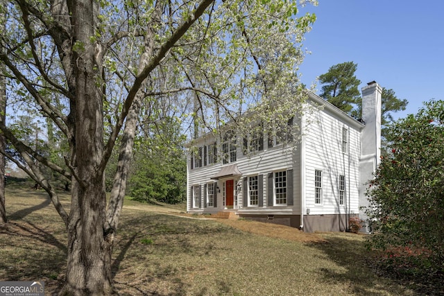 colonial inspired home with crawl space, a front yard, and a chimney