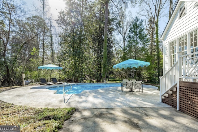 pool with outdoor dining area and a patio