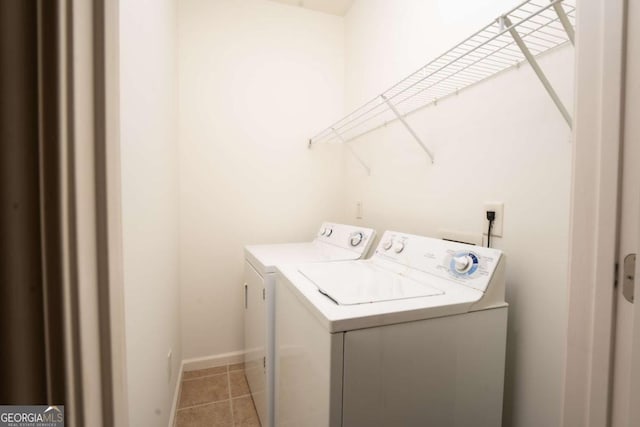 laundry room with washer and dryer, laundry area, light tile patterned flooring, and baseboards