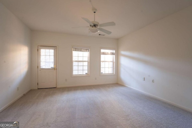 spare room featuring plenty of natural light, baseboards, carpet floors, and ceiling fan