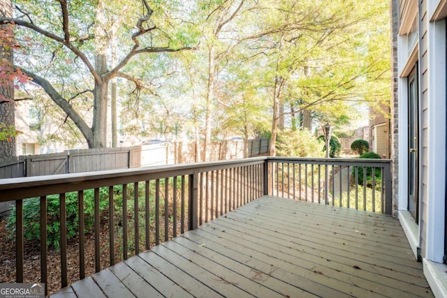 wooden terrace with a fenced backyard