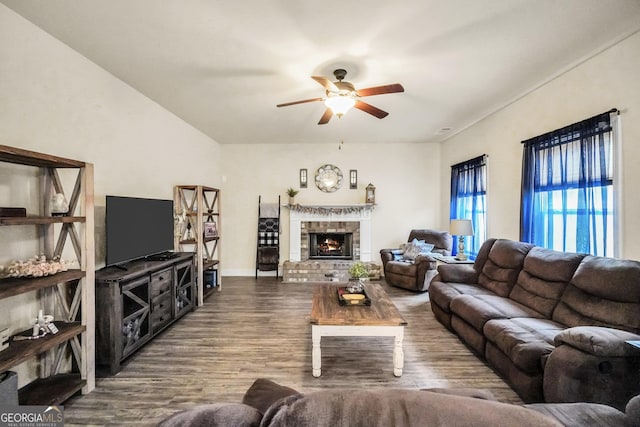 living room with a fireplace, wood finished floors, and a ceiling fan