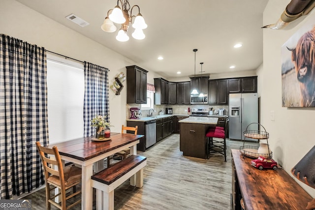 kitchen with visible vents, a sink, appliances with stainless steel finishes, light countertops, and a chandelier