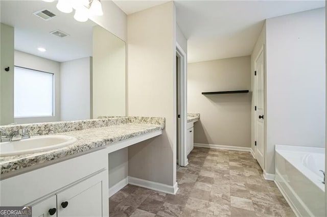 full bathroom with baseboards, visible vents, vanity, and a garden tub