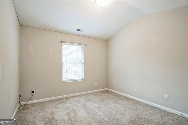 carpeted spare room featuring visible vents, baseboards, and vaulted ceiling