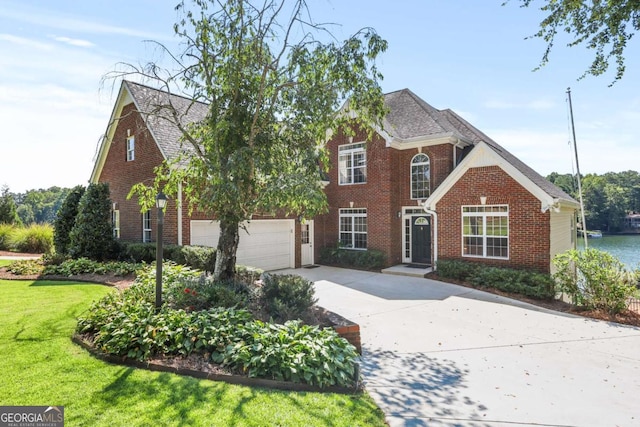 traditional home featuring a garage, brick siding, concrete driveway, and a front yard