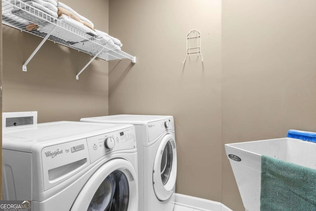 laundry room with laundry area, baseboards, and washer and clothes dryer