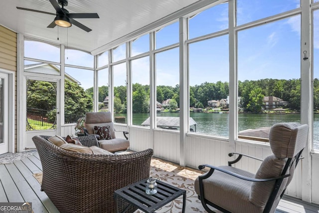 sunroom with a wealth of natural light, ceiling fan, and a water view