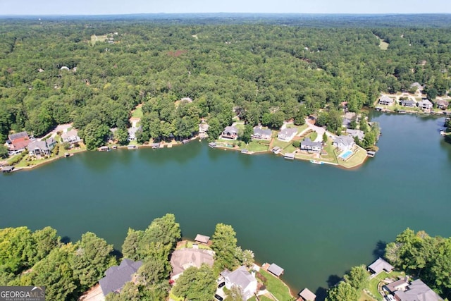 drone / aerial view with a residential view, a forest view, and a water view