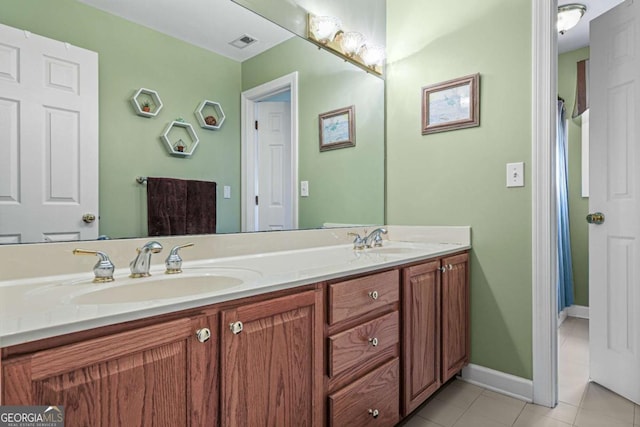 bathroom featuring tile patterned floors, double vanity, visible vents, and a sink