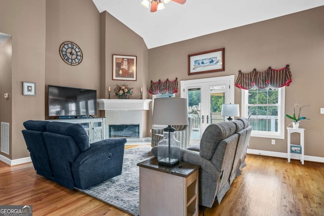 living area featuring visible vents, baseboards, wood finished floors, and a ceiling fan