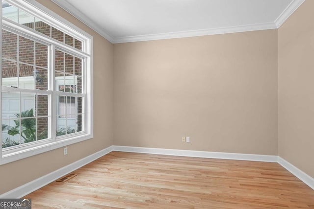 unfurnished room featuring light wood-type flooring, baseboards, and ornamental molding