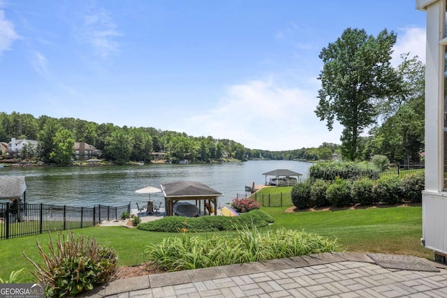 exterior space with a gazebo, fence, a yard, and a water view