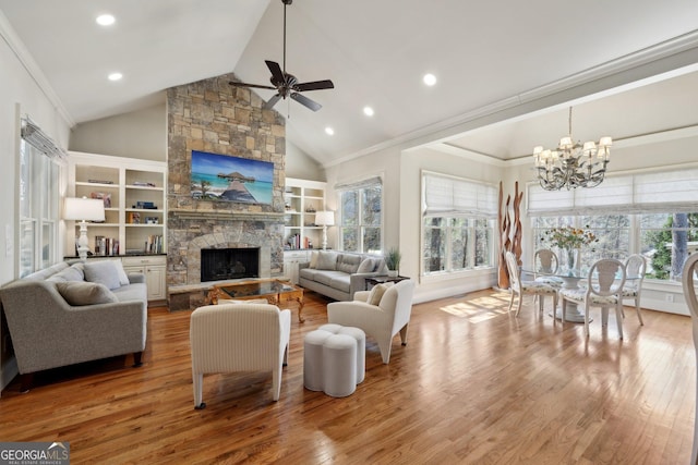 living area featuring a fireplace, wood finished floors, ceiling fan with notable chandelier, and ornamental molding