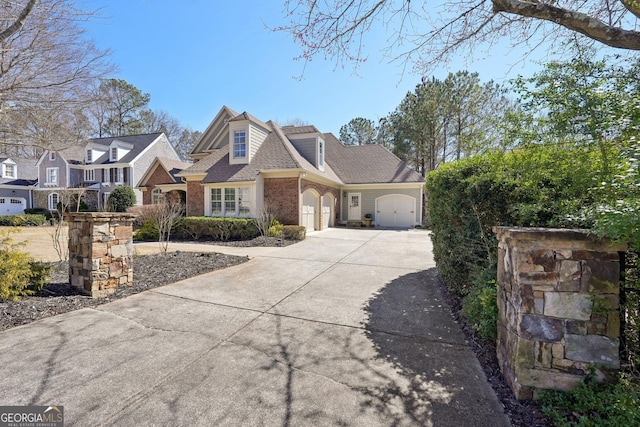 view of front of property featuring concrete driveway, an attached garage, brick siding, and a shingled roof