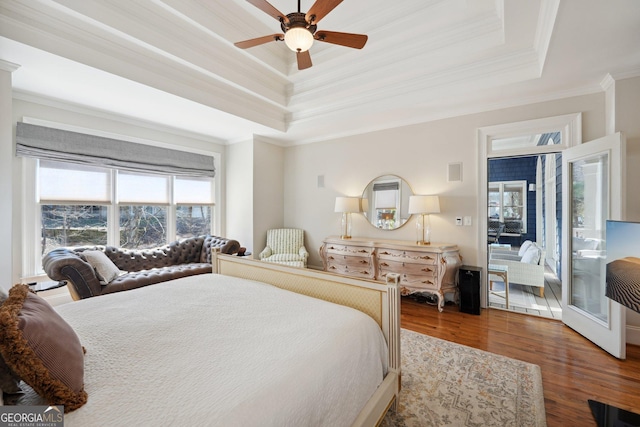 bedroom with crown molding, a raised ceiling, a ceiling fan, and wood finished floors