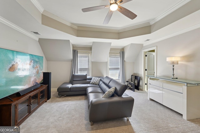 living area featuring a tray ceiling, a ceiling fan, visible vents, and light carpet