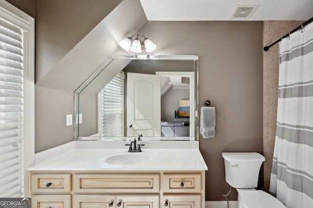 bathroom with visible vents, toilet, vanity, and plenty of natural light