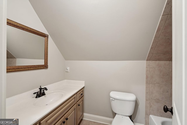 full bathroom featuring baseboards, toilet, lofted ceiling, tile patterned floors, and vanity