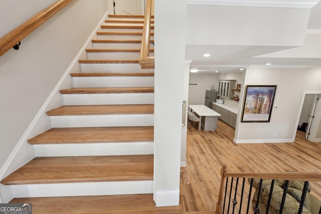 stairway with recessed lighting, baseboards, and wood finished floors