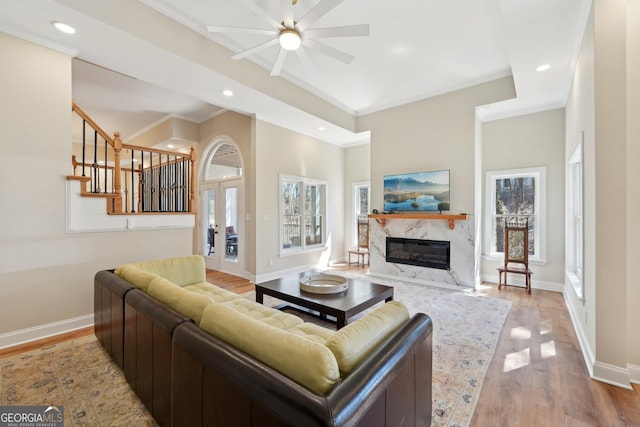 living room with ceiling fan, baseboards, wood finished floors, and a high end fireplace